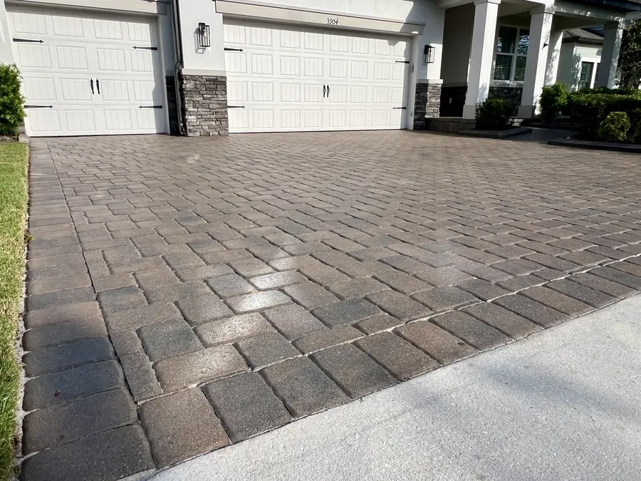 Wet-look sealed driveway with a glossy sheen reflecting the light