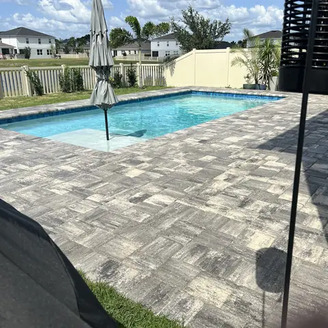 Sealed paver patio around a backyard pool
