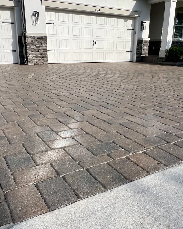 Wet-look sealed paver driveway in front of a three-car garage